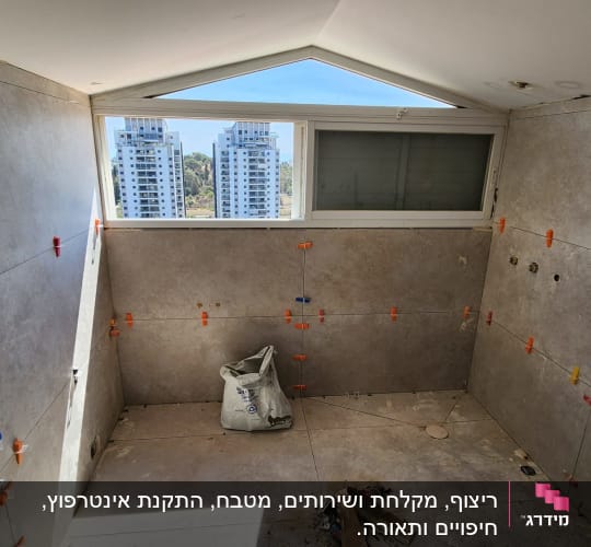 חדר עם אריחים מותקנים, חלון גדול, שקית בנייה על הרצפה